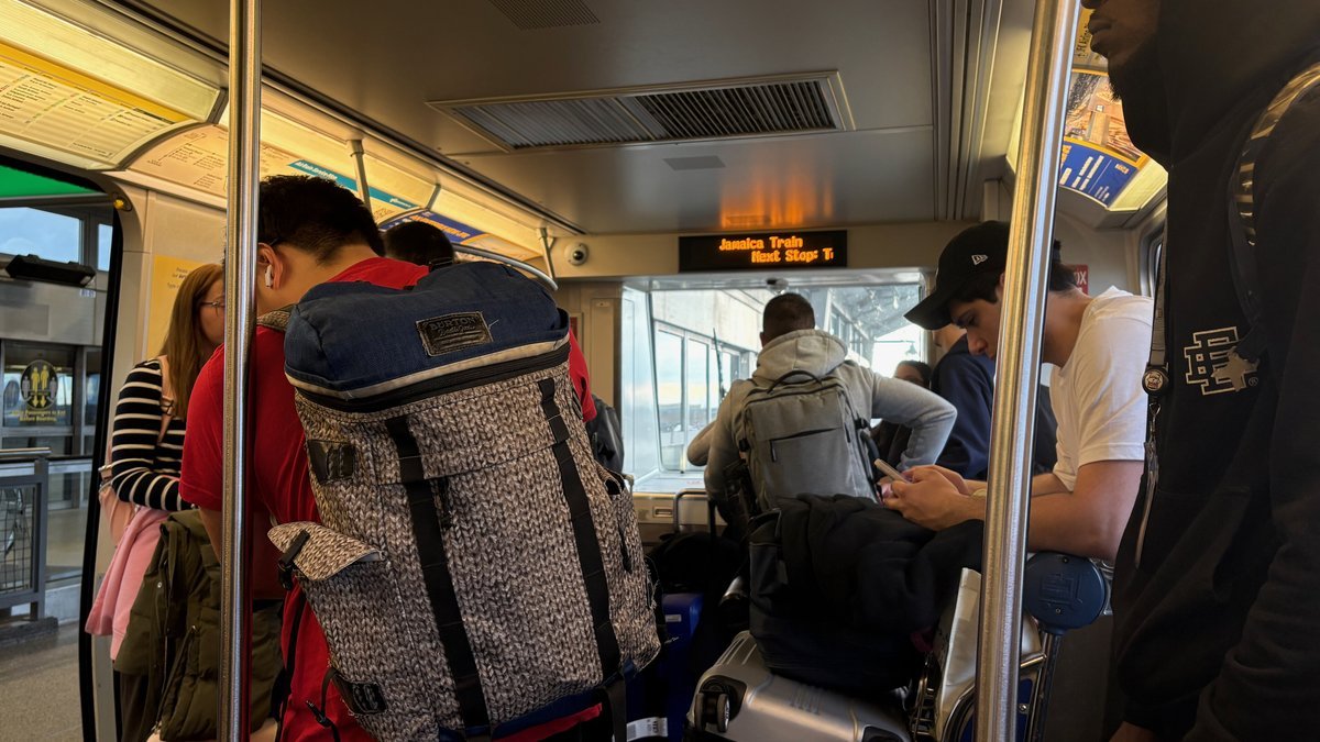 Passengers on a Jamaica Train in NYC, likely AirTrain JFK, with luggage.