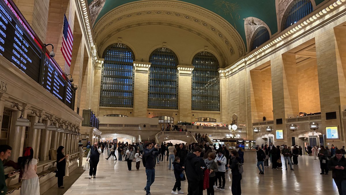 Grand Central Terminal main concourse at night with crowds and departures board, transit hub for day trip Hamptons travelers.