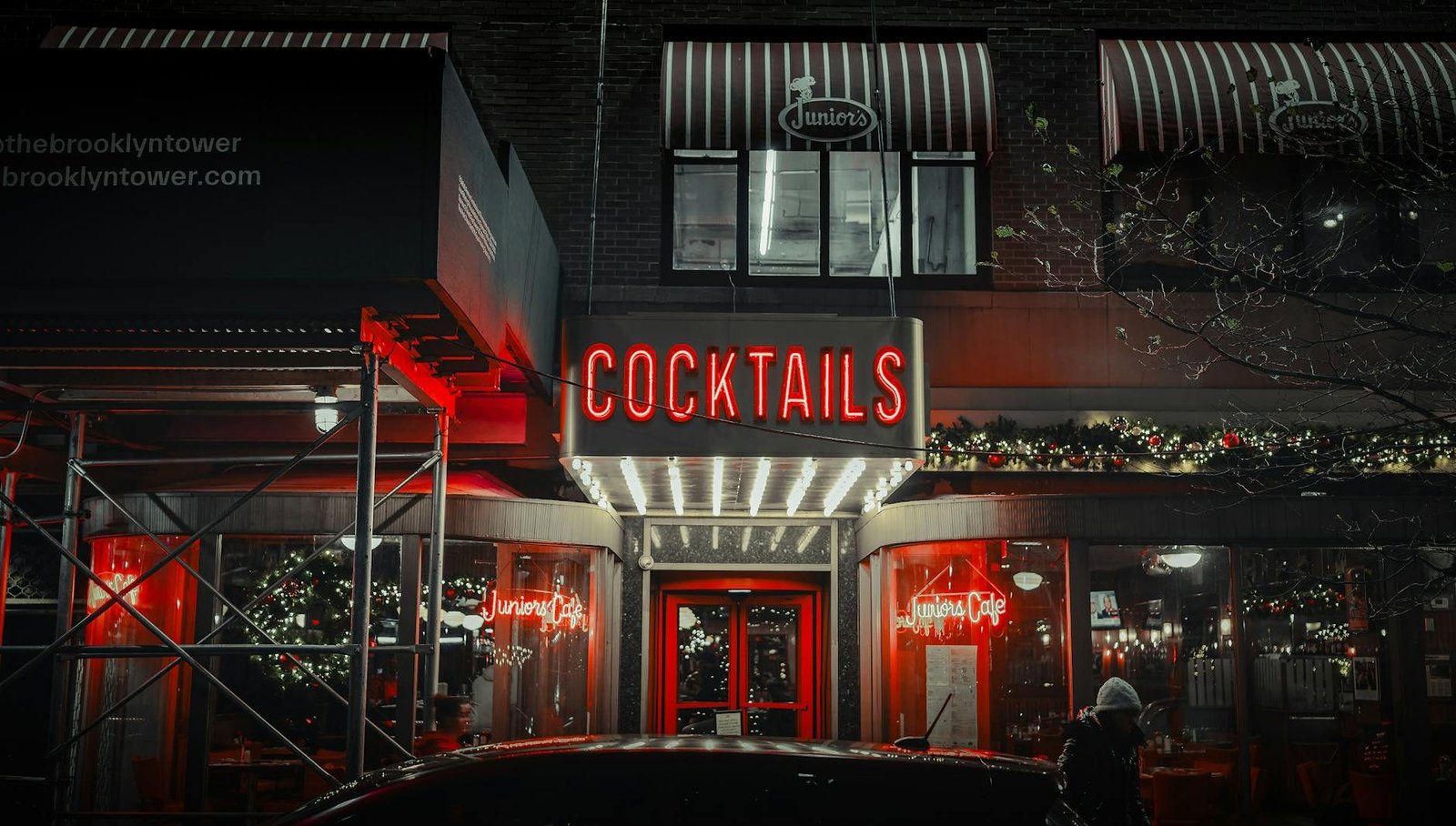 Restaurant interior at night with neon cocktails sign and holiday lights, dining experiences for day trips to Washington DC.