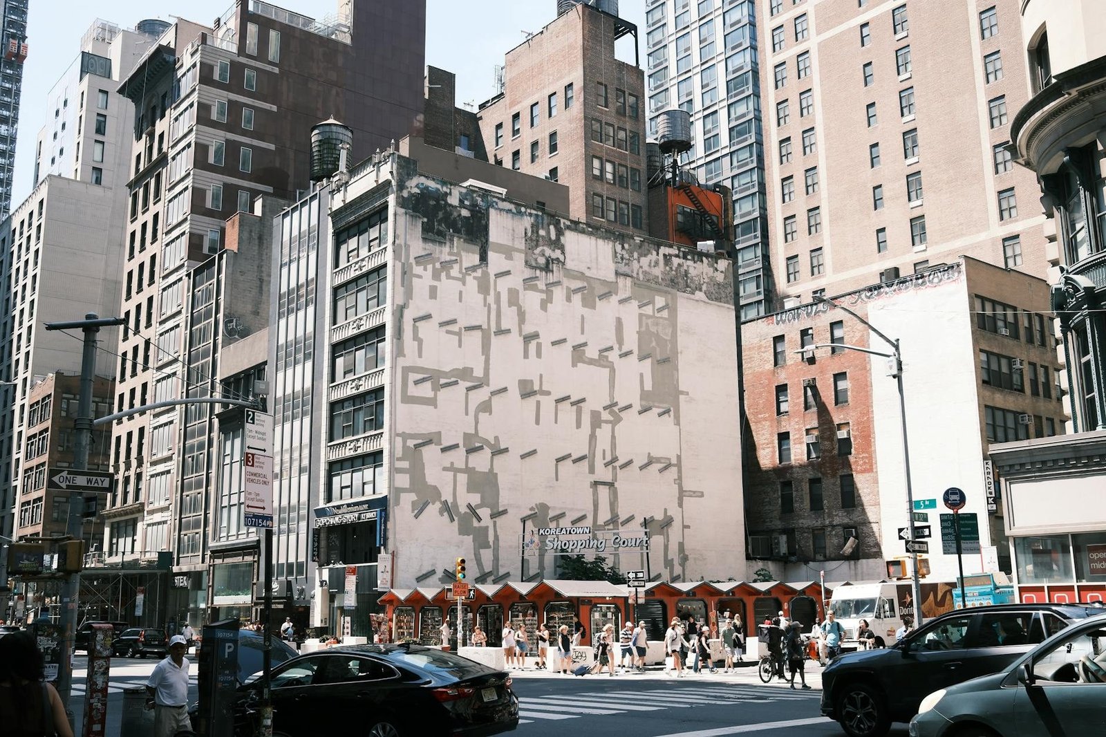 Koreatown Shopping Court en Nueva York, calle con edificios, gente y tráfico.
