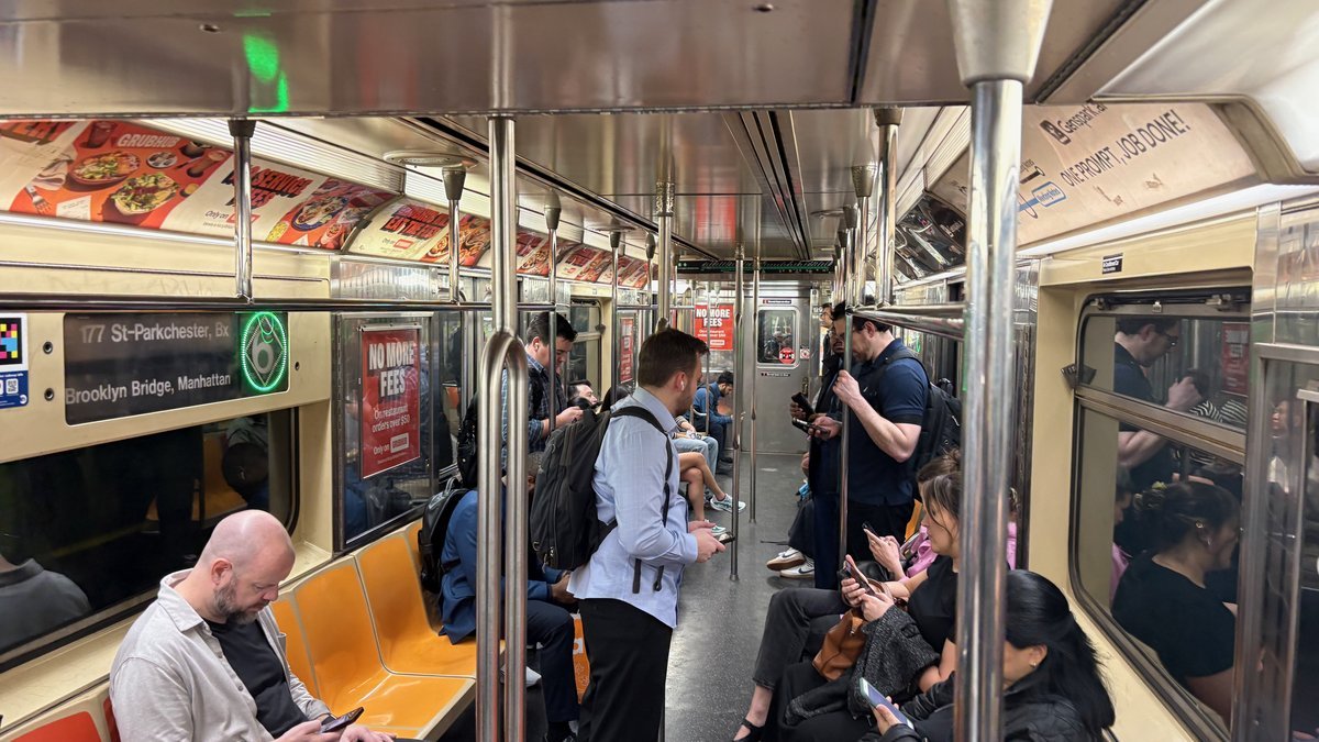 Interior of crowded train car with diverse passengers, Northeast Corridor transit for day trips to Washington DC.