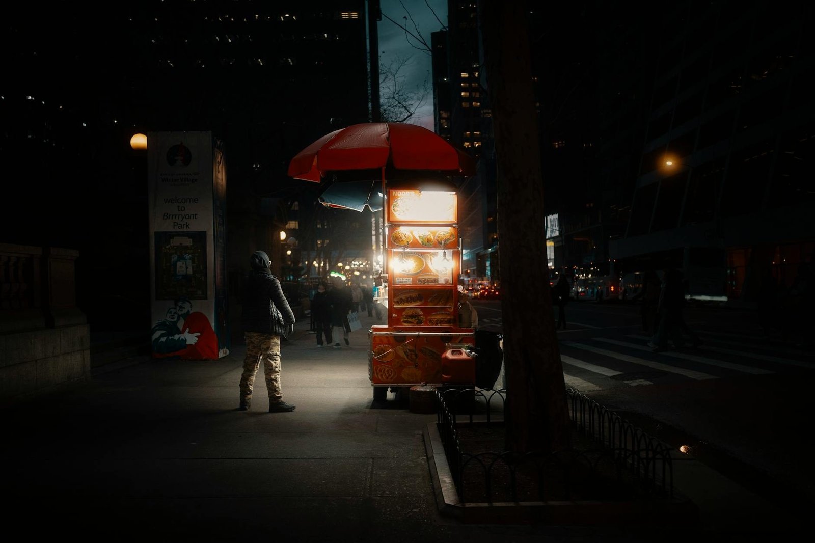 Night view of a food cart at Bryant Park, Midtown Manhattan street scene.