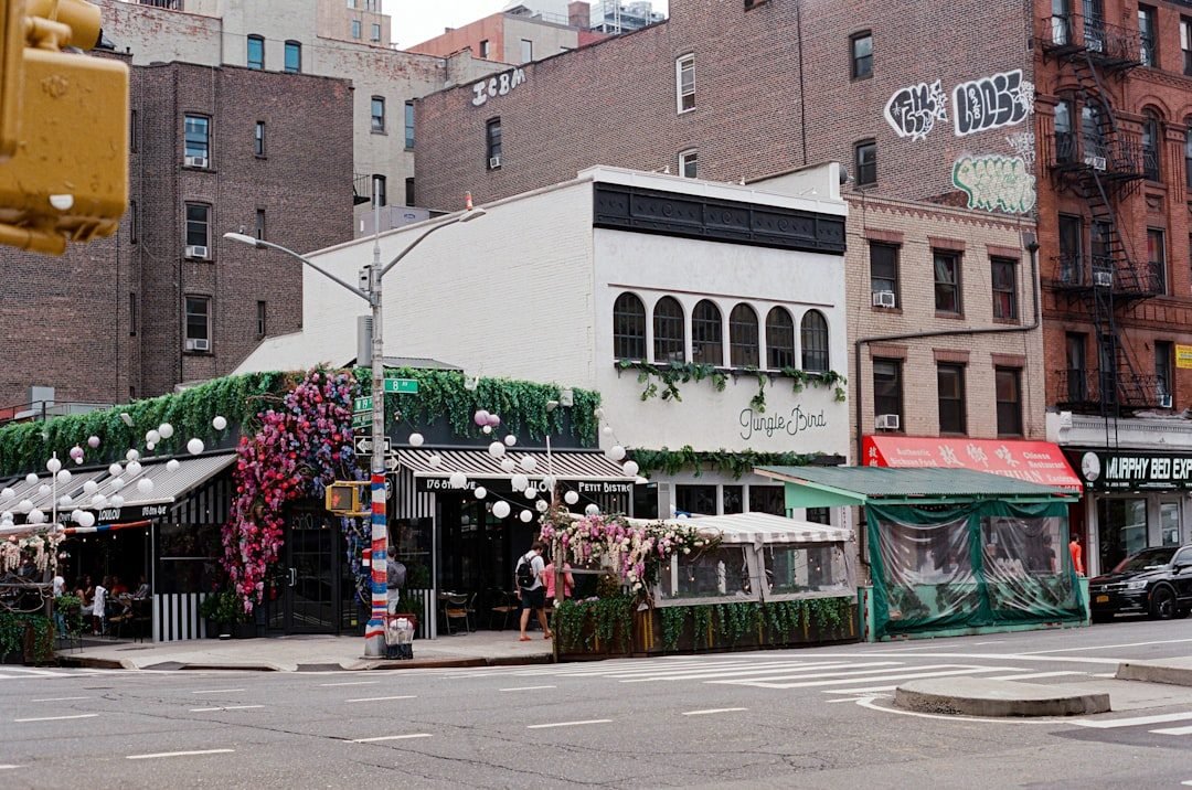 Chelsea street corner with Loulou Petit Bistro, Jungle Bird, and floral decorations on 8th Avenue.