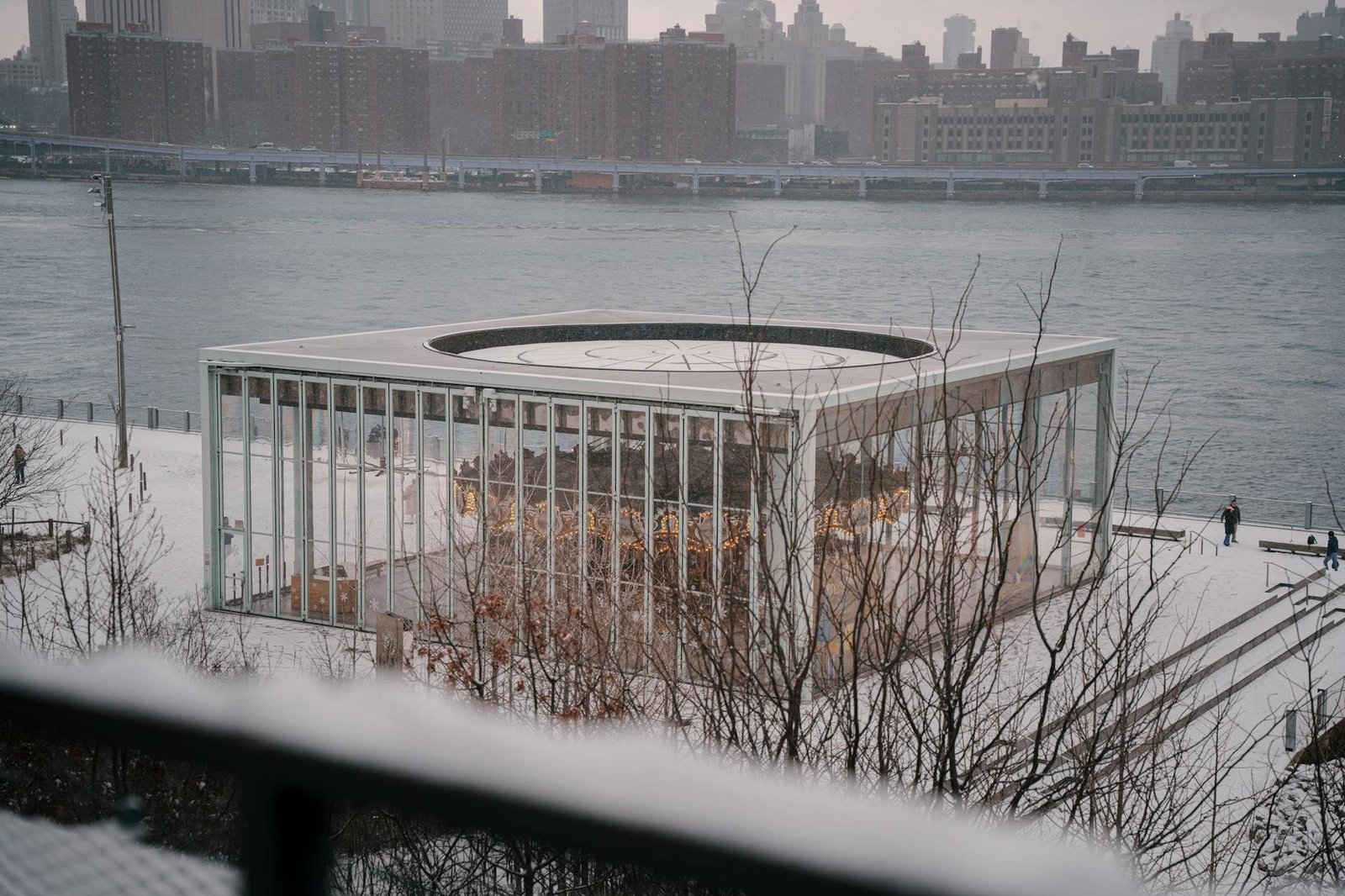 Jane's Carousel en Brooklyn Bridge Park cubierto de nieve con el skyline de Manhattan.