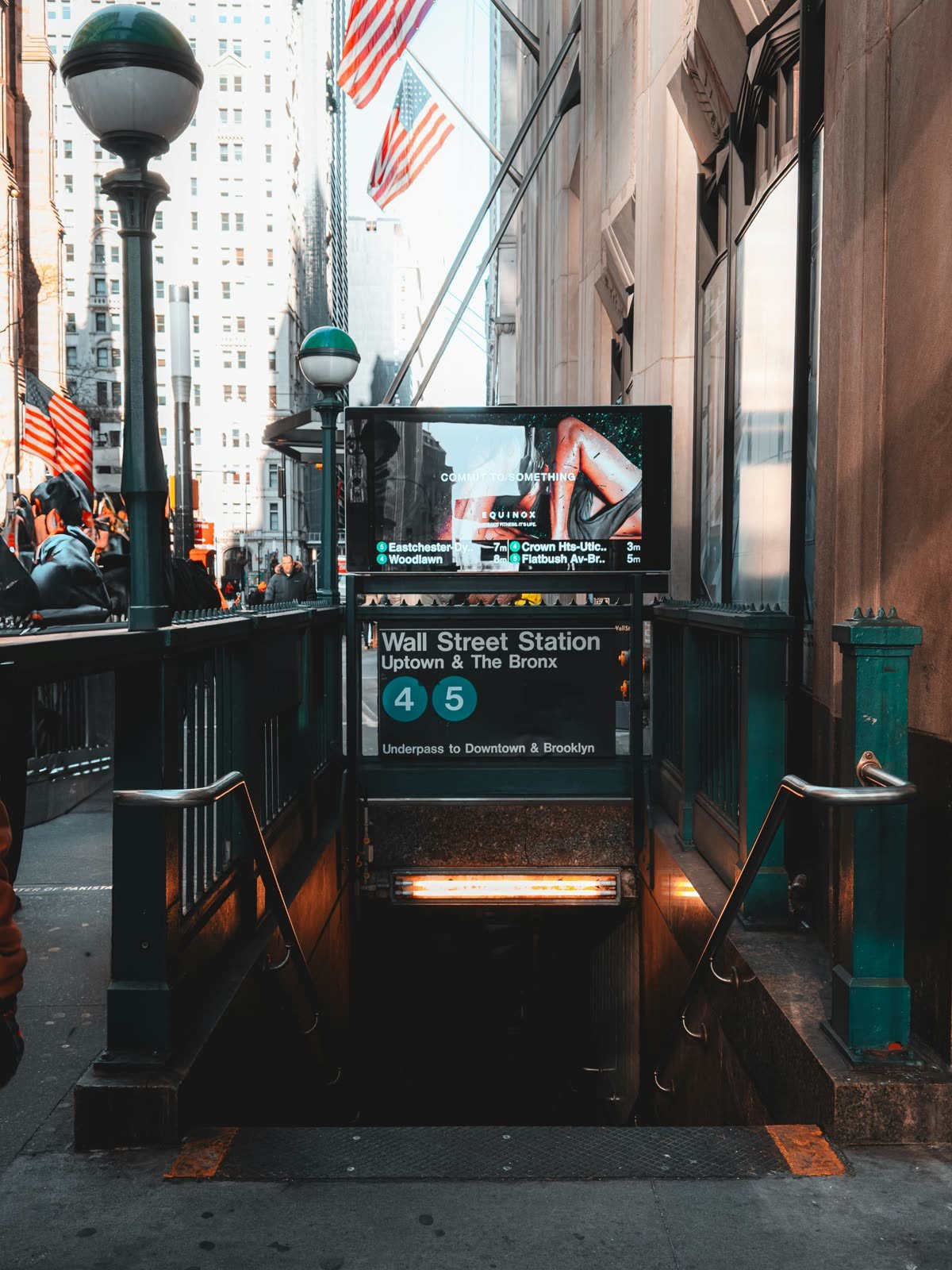 Wall Street subway station entrance with American flags in Lower Manhattan