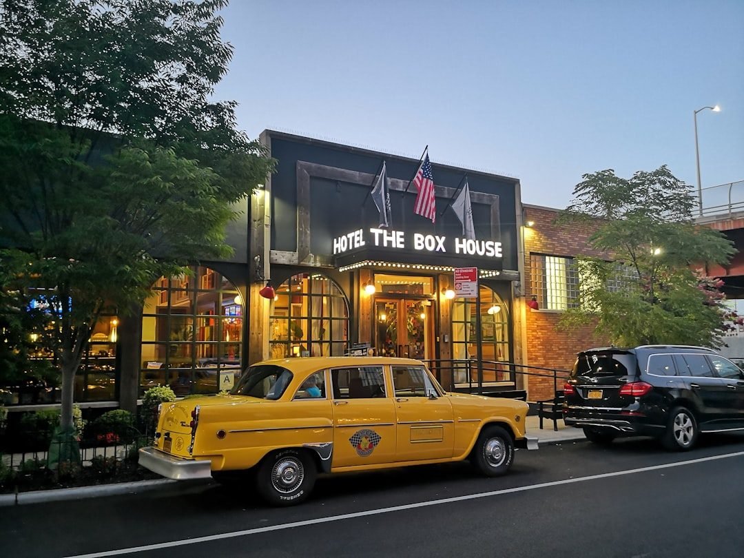 The Box House Hotel Greenpoint exterior at dusk with classic yellow taxi.