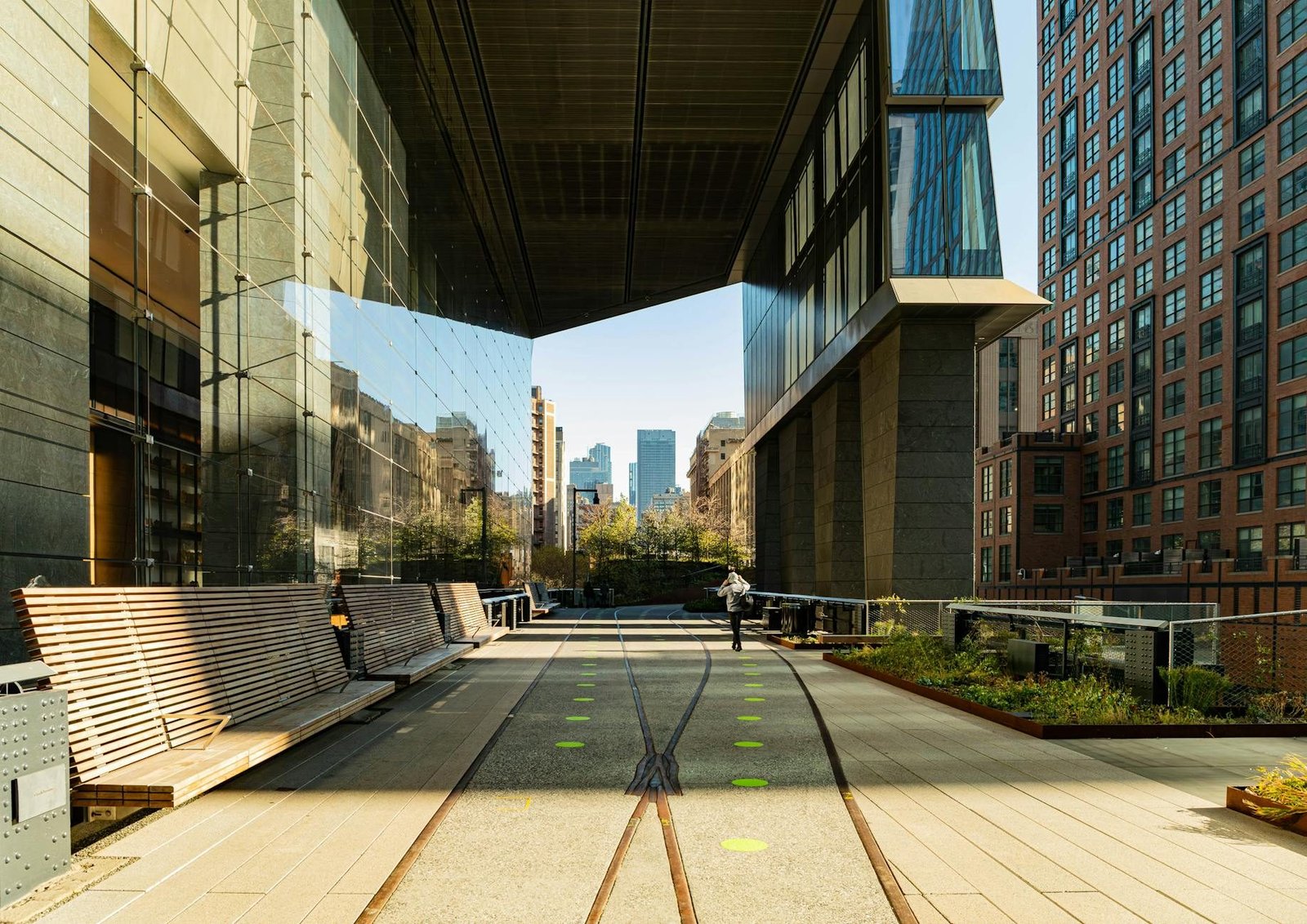 The High Line park in NYC with modern architecture and sunny path.