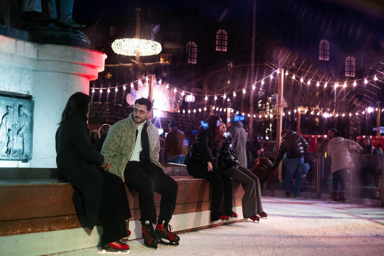 Gente patinando en Wollman Rink Central Park, luces festivas de invierno en NYC.